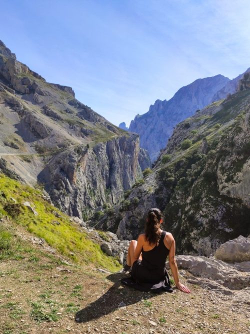 Paula sentada en el desfiladero disfrutando de la montaña en un día de verano