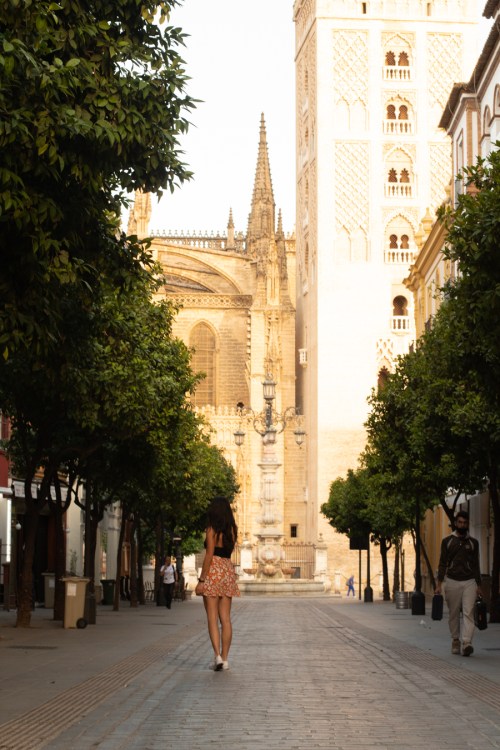 chica caminando en Sevilla con vistas a la Giralda