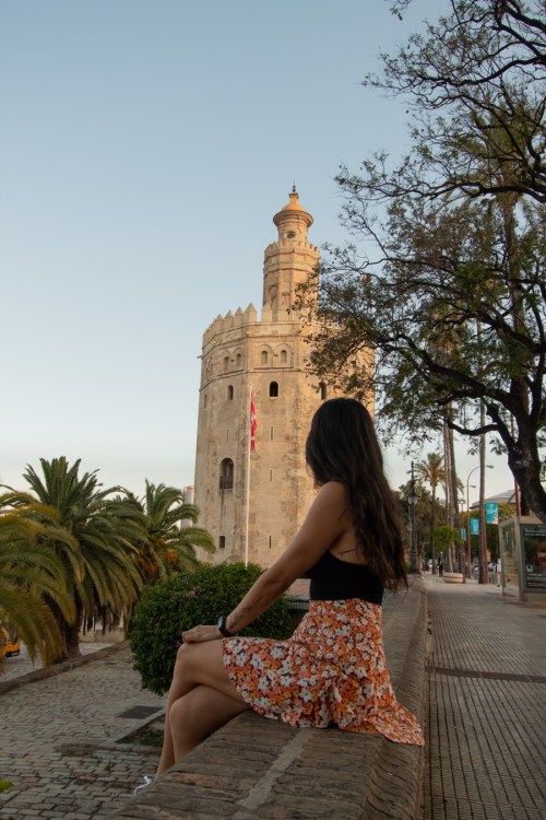 Chica mirando la Torre del Oro en Sevilla